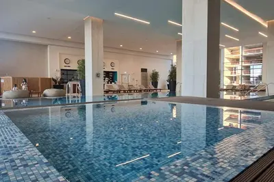 a large swimming pool in a hotel lobby at Queen Apartments Belgrade Waterfront in Belgrade