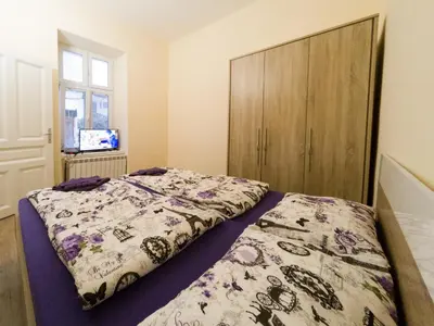 a bedroom with a bed and a wooden cabinet at Apartment Ema in Belgrade