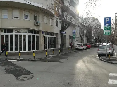 a street with cars parked in front of a building at Belgrade Center Apartment Skadarlija in Belgrade