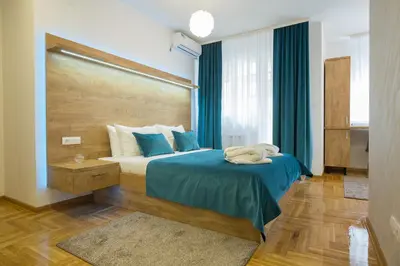 a bedroom with a bed with a blue comforter at Thomas Residence in Belgrade