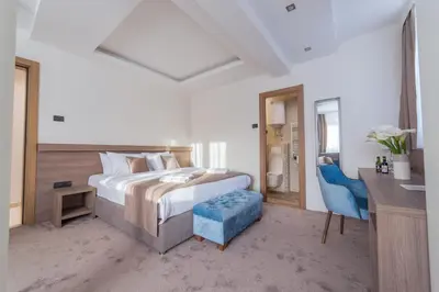 a bedroom with a bed and a desk and a chair at M House Belgrade Residence in Belgrade