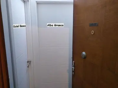 a door with two signs on it next to a wooden door at Alba Graeca in Belgrade