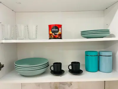 a bathroom with a toilet and bowls and cups on shelves at Luxury Centar in Arandjelovac