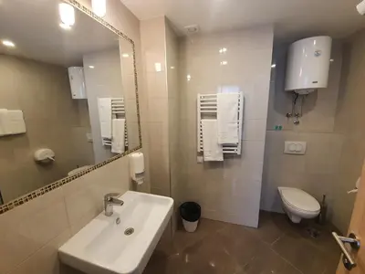 a bathroom with a sink and a toilet and a mirror at Premium Crown Suites in Belgrade