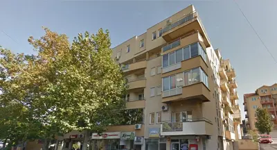 a tall building with a tree in front of it at Apartman 23 in Lazarevac
