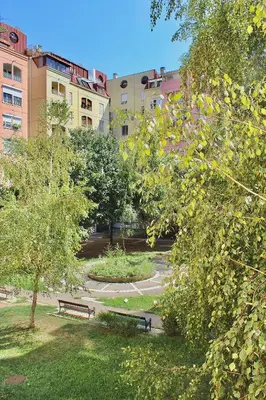 a park with benches and trees and buildings at Ramonda Residences - New Belgrade in Belgrade