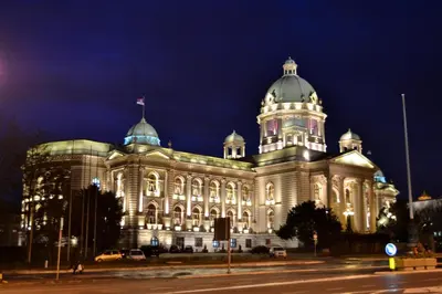 a large building with a flag on top of it at night at Belvedere Skadarska Apartment in Belgrade