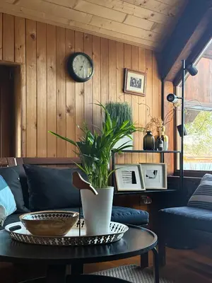 a living room with a table and a clock on the wall at River house Vasa in Belgrade