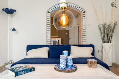 a blue couch in a living room with a table at Wine house apartment in Karaburma