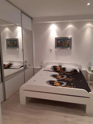 a white bedroom with a bed and a mirror at Djakuzi Viktorija in Belgrade