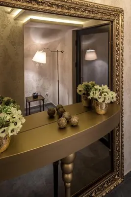 a mirror on a table with flowers on it at Belly in Vračar (historical)