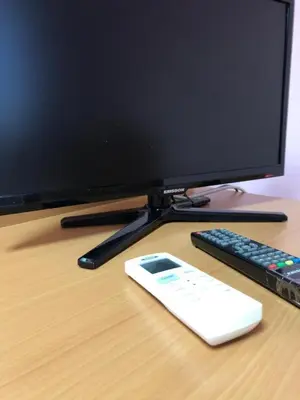 a computer monitor and a remote control on a desk at Sofia Apartment 2 in Surčin