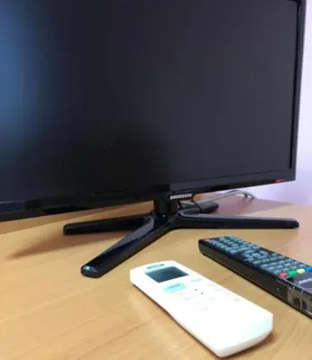 a computer monitor and a remote control on a desk at Luna Apartment in Surčin