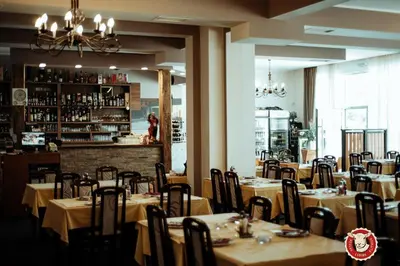 a restaurant with tables and chairs and a bar at Sara Apartment in Surčin