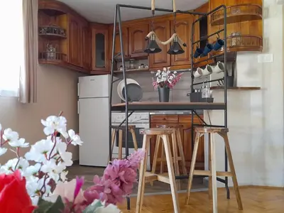 a kitchen with wooden cabinets and a counter with stools at Apartman AS in Belgrade