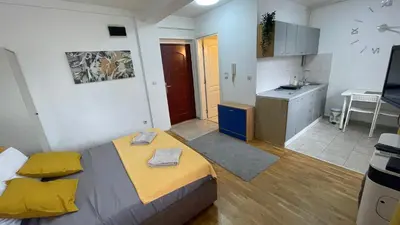 a small room with a bed and a kitchen at Voždovac Vitanovacka in Belgrade