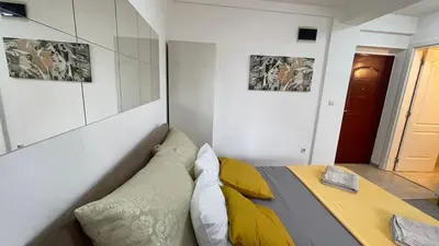 a bedroom with a bed with yellow pillows at Voždovac Vitanovacka in Belgrade