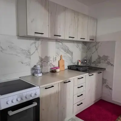 a kitchen with white cabinets and a counter top at Apartman Giovanni 2 in Arandjelovac