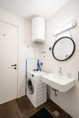a bathroom with a washing machine and a sink at Apartment Atrium- A blok in Novi Beograd