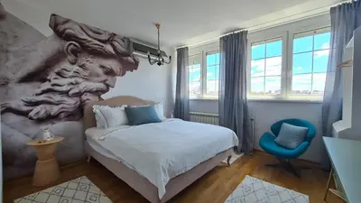 a bedroom with a bed and a large painting on the wall at Zeus Nest Apartment in Belgrade