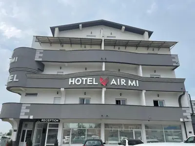 a hotelarmaarma building with cars parked in front of it at AirMi hotel in Surčin
