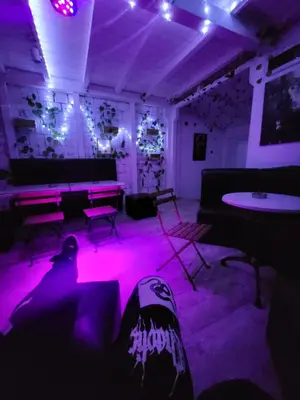a room with purple lighting and a table and chairs at cunami kucica sa bazenom in Belgrade