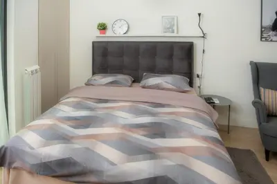 a bedroom with a bed with a camouflage bedspread at Belgrade Waterfront Metropolitan in Belgrade
