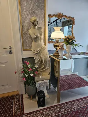 a statue of a woman sitting next to a table at VANSVEL Boutique Apartment 7 in Belgrade