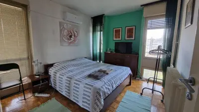 a bedroom with a bed and a green wall at Sava Centar in Novi Beograd