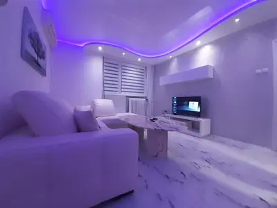 a living room with a white couch and a tv at Viktorija 1 in Čukarica