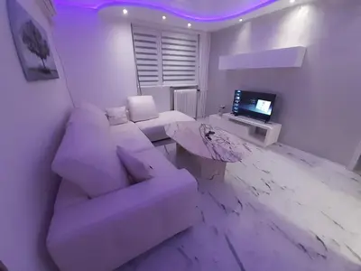 a white living room with a couch and a table at Viktorija 1 in Čukarica