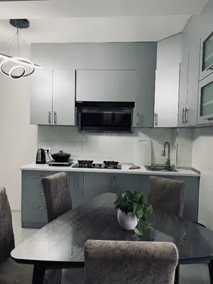 a kitchen with a table and chairs and a kitchen with white cabinets at \u99a8\u4e4b\u5bb6-\u534e\u4eba\u516c\u5bd3\u6c11\u5bbf \u4e09\u5ba4\u4e00\u5385 in Ledine