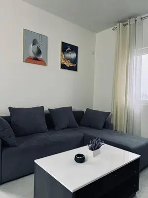 a living room with a blue couch and a white table at \u99a8\u4e4b\u5bb6-\u534e\u4eba\u516c\u5bd3\u6c11\u5bbf \u4e8c\u5ba4\u4e00\u5385 in Ledine