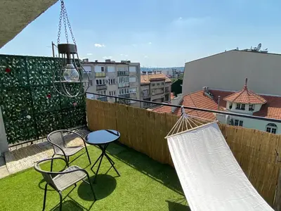 a patio with chairs and hammocks on a balcony at Panorama Royal Vračar in Vračar (historical)