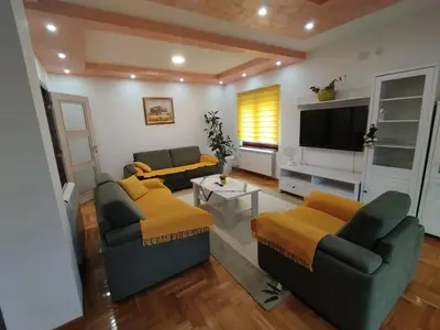 a living room with two couches and a flat screen tv at Stan Ledine in Ledine