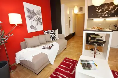 a living room with a couch and a red wall at Boutique Apartments 360º in Belgrade