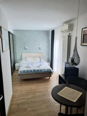 a bedroom with a bed and a couch and a table at Dixy 2 in Belgrade