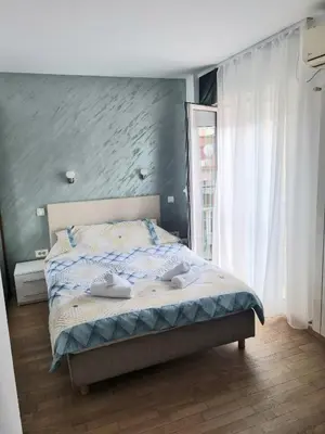 a bedroom with a bed in a room with a window at Dixy 2 in Belgrade