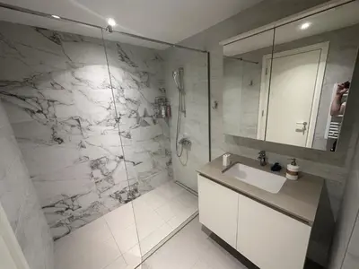 a white bathroom with a sink and a shower at Belgrade Waterfront Wolf in Sajmište